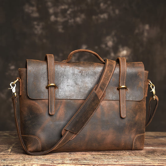 Briefcase/messenger bag in top-grain cowhide with a vintage style; features a shoulder strap suitable for crossbody wear.